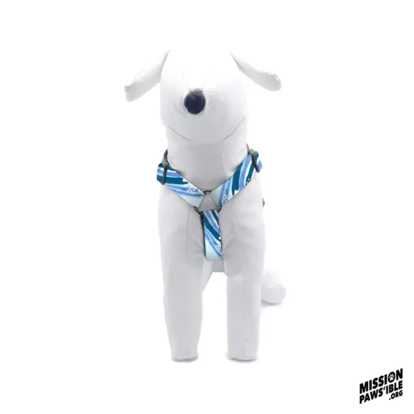 White plush dog wearing the Wave Runner Adjustable Harness, showcasing a blue and white striped design, with the "Mission Paws'ible" logo in the bottom corner.