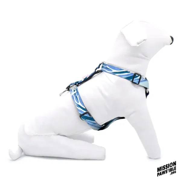 A white mannequin dog sits wearing the Wave Runner Adjustable Harness, featuring a blue and white pattern. The "Mission Paws'ible .org" logo is in the bottom right corner.