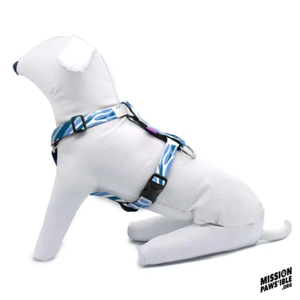 A stuffed white dog mannequin is sitting in profile view, wearing a Wave Runner Adjustable Harness in blue and white. The logo in the bottom right corner reads "MISSION PAWS'IBLE .ORG".