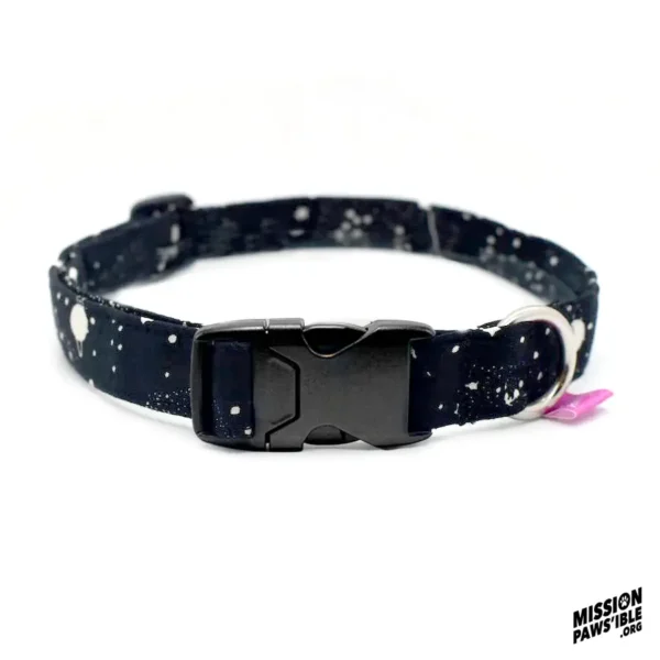 The "Into The Cosmos Collar," featuring a black and white speckled design with a plastic buckle and metal ring, is showcased on a white background with the "Mission Paws'ible" logo in the corner.