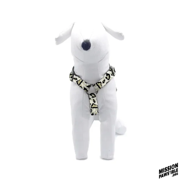 A white dog mannequin showcasing the Hear Me Roar Adjustable Harness in leopard print, with the Mission Paws'ible logo in the lower right corner.