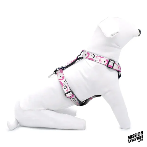 A dog mannequin, colored white and displayed in a sitting pose, is wearing a Flirty Flamingos Adjustable Harness featuring a pink and white design with flamingo patterns.