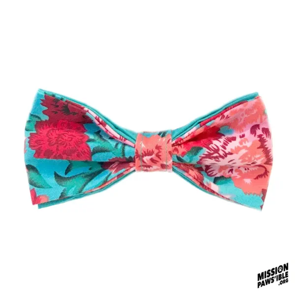 Introducing the Flower Power Aqua Bow Tie, a vibrant fabric bow tie featuring a beautiful floral pattern in shades of pink, red, and blue with the words "Mission Paws'ible" elegantly displayed in the bottom right corner.