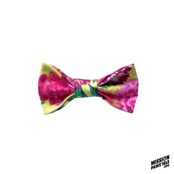 The "Flower Power Yellow Mini Bow Tie" features a floral pattern showcasing shades of pink, green, and yellow on a white background, with the Mission Pawsible logo in the bottom right corner.