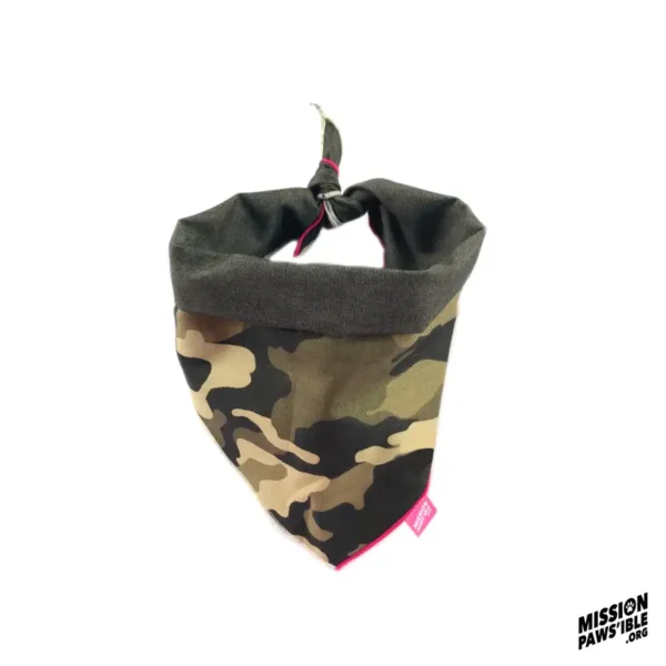 The Onyx Reversible Bandana features a camouflage design with a tie knot at the top and includes a small red tag on the edge, with the Mission Paws'ible logo positioned in the bottom right corner.