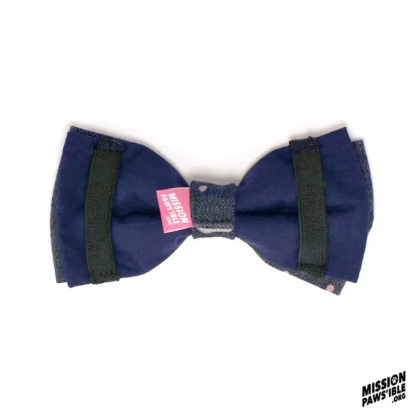 A Spot On Denim Cool Bow Tie featuring blue denim with black bands and a small pink tag in the center, showcased on a white background. The text "MISSION PAWSIBLE" appears in the bottom right corner.