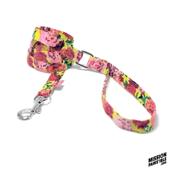 The Flower Power Yellow Lead, featuring a colorful floral design with a metal clip and handle, is coiled on a white background, with the "Mission Paws'ible" logo in the corner.